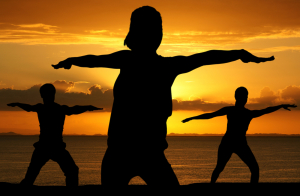 Group of people doing yoga while at the beach